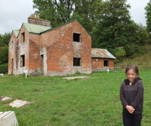 Standing by a building in Imber