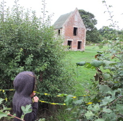 Standing by a building in Imber